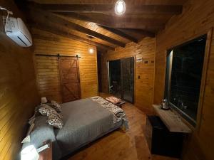 a bedroom with a bed in a room with wooden walls at Tierra Guaraní Lodge in Puerto Iguazú