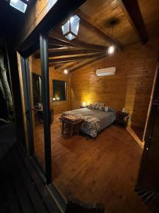 1 dormitorio con 1 cama en una habitación de madera en Tierra Guaraní Lodge en Puerto Iguazú