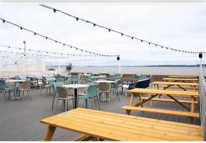 a deck with tables and chairs on the beach at Newland's in Rochester