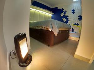 a bedroom with a bed and a light on the floor at Family House - Curitiba in Curitiba