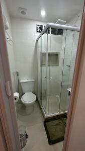 uma casa de banho com um WC e uma cabina de duche em vidro. em Studio Reformado coração Leblon no Rio de Janeiro