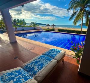una piscina junto a una playa con el océano en Beachfront Villa en Rincon de Guayabitos