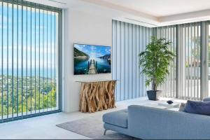 a living room with a blue couch and large windows at Costa d'en Blanes villa SeA ViEw in Costa d'en Blanes