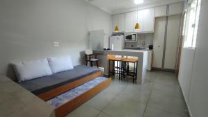 a small room with a bed and a kitchen at Family House - Curitiba in Curitiba