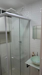 uma casa de banho com uma cabina de duche em vidro e um lavatório. em Studio Reformado coração Leblon no Rio de Janeiro