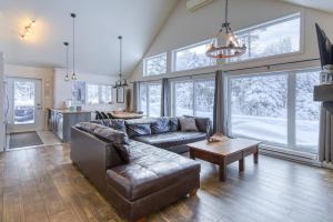 a living room with a couch and a table at 46 Impasse - Lac Superior Getaway 3BR Home w Hot Tub in Mont-Tremblant