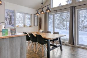 cocina y comedor con mesa de madera y sillas en 46 Impasse - Lac Superior Getaway 3BR Home w Hot Tub, en Mont-Tremblant
