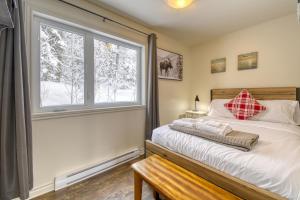 1 dormitorio con cama y ventana en 46 Impasse - Lac Superior Getaway 3BR Home w Hot Tub, en Mont-Tremblant