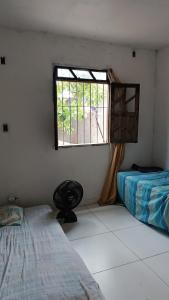 een kamer met 2 bedden en een raam bij Casa na ilha de Itaparica in Itaparica Town