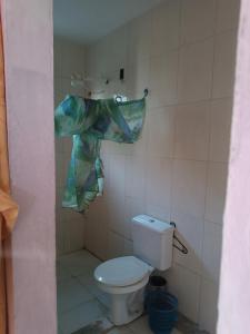 a bathroom with a toilet and a shower curtain at Casa na ilha de Itaparica in Itaparica Town