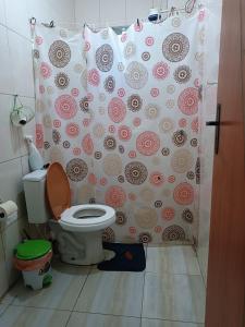 a bathroom with a toilet and a shower curtain at Casa na ilha de Itaparica in Itaparica