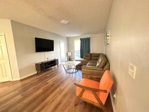 ein Wohnzimmer mit einem Sofa und einem TV in der Unterkunft Sunset themed retreat- Sleeps 10 in Davenport