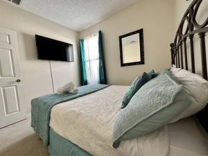 1 dormitorio con 1 cama y TV de pantalla plana en Sunset themed retreat- Sleeps 10 en Davenport