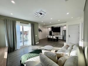 ein Wohnzimmer mit einem weißen Sofa und einer Küche in der Unterkunft High end apt 5 min to downtown/15 min to beach in St Petersburg