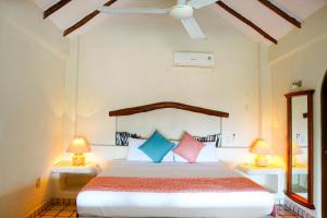 a bedroom with a large bed with two lamps at Villas San Sebastian in Zihuatanejo