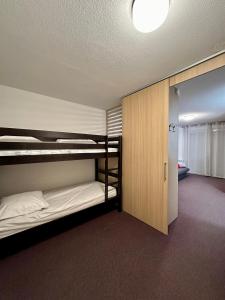 Cette chambre comprend 2 lits superposés et un placard. dans l'établissement Aux pieds des pistes, à La Foux