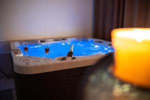 a man in a hot tub with two glasses of wine at Kuća za odmor Mali raj-Kupres in Kupres