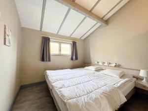 a large bed in a room with a window at Pur Sea vakantiehuis te Middelkerke / Westende in Middelkerke