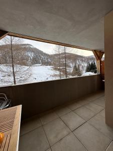 Cette chambre dispose d'une grande fenêtre offrant une vue sur la montagne enneigée. dans l'établissement Aux pieds des pistes, à La Foux