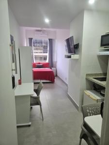 Habitación con cama roja y habitación con ventana en Studio Reformado coração Leblon, en Río de Janeiro