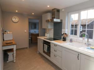 a kitchen with a sink and a stove top oven at 2 Greensleeves in Saxmundham