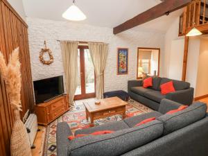 uma sala de estar com um sofá e uma televisão em 3 Home Farm South em Rousdon