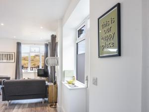 a living room with a door with a happy place sign at Lyme Zest in Lyme Regis