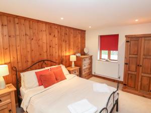 3 Home Farm South في Rousdon: غرفة نوم بسرير وجدار خشبي