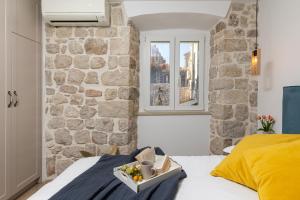 Un dormitorio con una pared de piedra y una cama en Nono's House II, en Dubrovnik