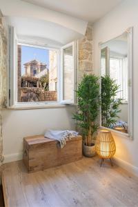 a room with a bench and two windows with plants at Nono's House II in Dubrovnik