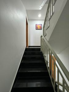 eine Treppe in einem Gebäude mit schwarzen Treppen in der Unterkunft Superbe Maison Khmer in Phnom Penh