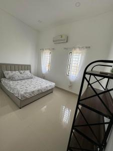 a white bedroom with a bed and a ladder at Superbe Maison Khmer in Phnom Penh