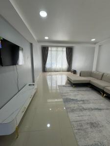een grote woonkamer met een bank en een tv bij Superbe Maison Khmer in Phnom Penh