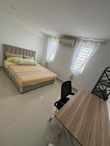 a bedroom with a bed and a table and two windows at Superbe Maison Khmer in Phnom Penh