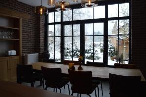 a room with a table and chairs and a large window at La Jardinière in Érezée