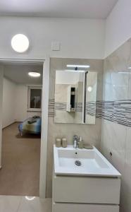 a white bathroom with a sink and a bedroom at *Veranda's rooms* - Free parking in central Lugano in Lugano