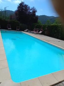 una gran piscina azul con 2 sillas de césped en Agri BERTORELLA, en Cuneo