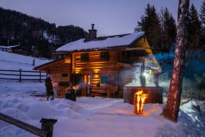 una cabaña de madera en la nieve por la noche en Almfrieden, en Werfen