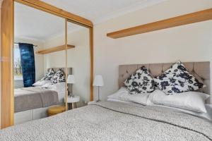 1 dormitorio con cama y espejo grande en Cozy Apartment in Greater London – 1BR,1 Bath en Londres