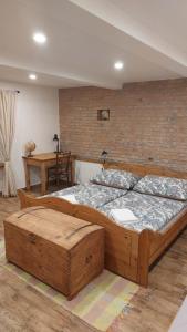 um quarto com uma grande cama de madeira e uma parede de tijolos em Apartmán Anglický roh em Františkovy Lázně