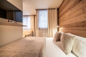 a bedroom with a white bed and a television at Eden Studio Chamonix Centre in Chamonix