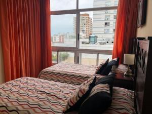two beds in a room with a window at ubicacion perfecta en punta in Punta del Este