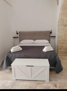 a white bed with a white table in a bedroom at Dimora Gassi in Mola di Bari