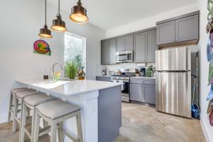 una cocina con armarios grises y una gran isla con taburetes. en Pet-Friendly Brentwood Home about 7 Mi to Downtown!, en Austin