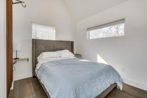Dormitorio blanco con cama con edredón azul en Pet-Friendly Brentwood Home about 7 Mi to Downtown!, en Austin