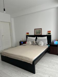ein Schlafzimmer mit einem Bett mit zwei ausgestopften Tieren darauf in der Unterkunft A quiet place - AB Homes - ap 3 rooms Netflix&chill in Iaşi