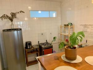 uma cozinha com um frigorífico e uma mesa com uma planta em Apt Charmoso 3 Quartos Gavea no Rio de Janeiro