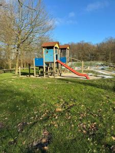 a playground with a slide in a park at Villa Mina in Bad Bentheim