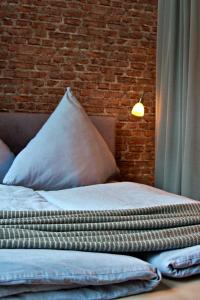 a bed with a pillow and a brick wall at Industrial Style 77qm mit Balkon in Herne