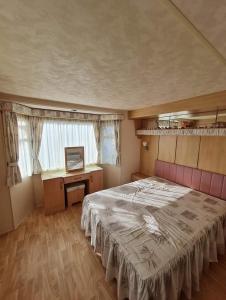 1 dormitorio con 1 cama grande y escritorio en GRAND BUNGALOW frond de mer sur la Côte d'Opale, en Camiers